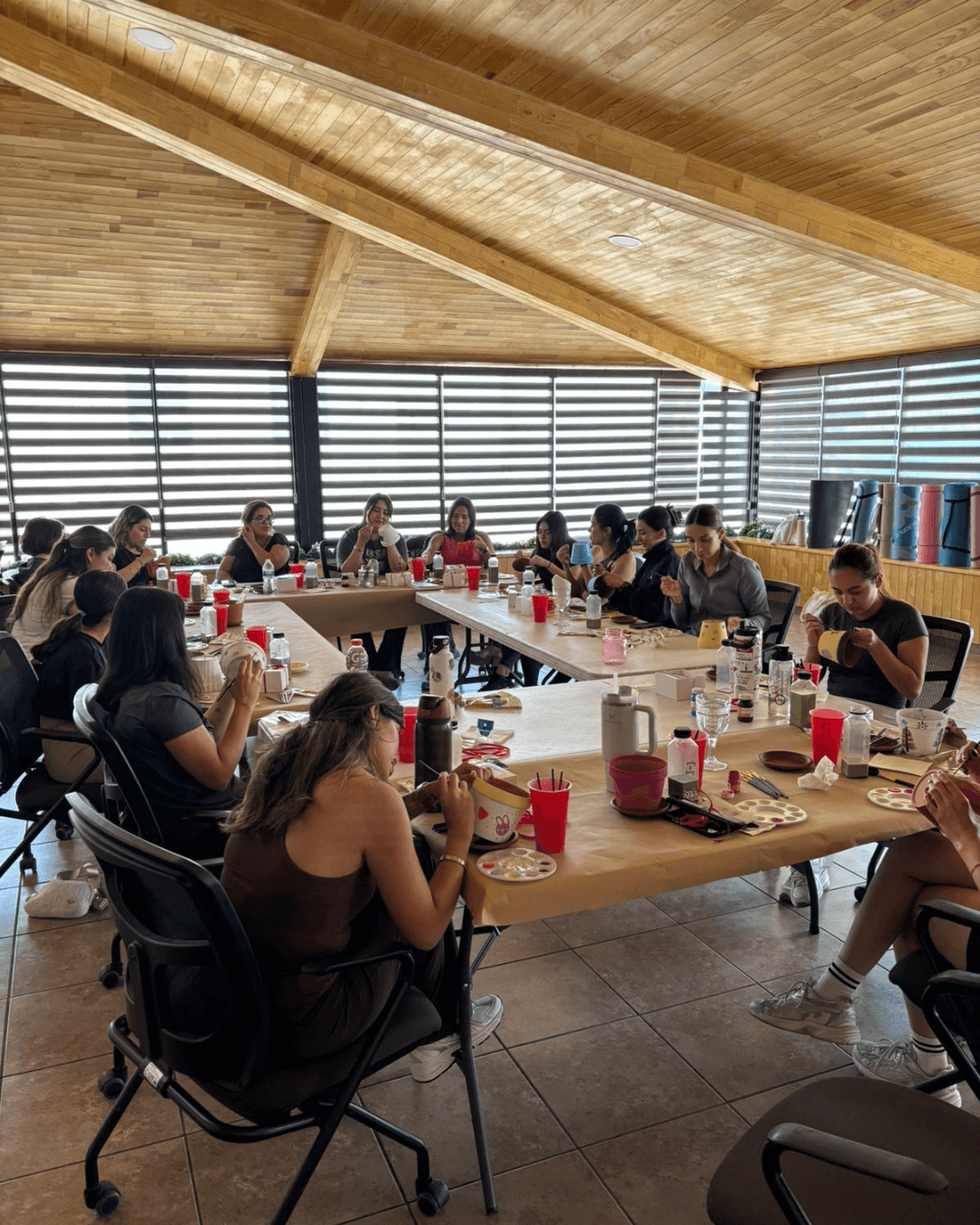 Grupo completo pintando macetas juntas durante el evento especial de mayo