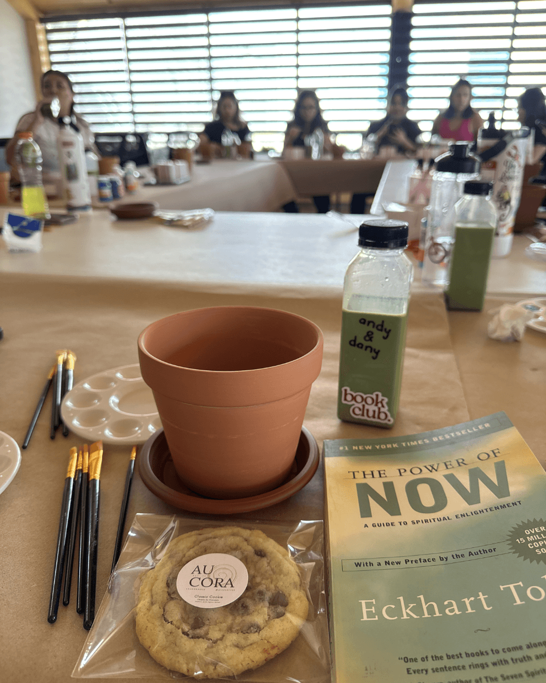 Detalle del evento slow morning: maceta de barro, matcha y el libro El poder del ahora